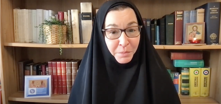 Sr. Vassa in front of bookshelf